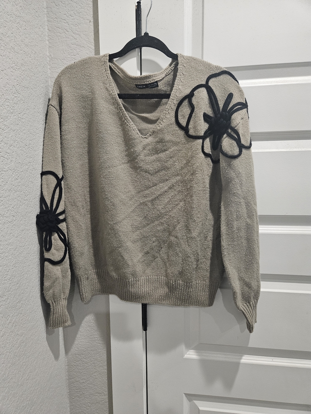 SHEIN Beige V‑Neck Sweater with Black Flower Appliqués